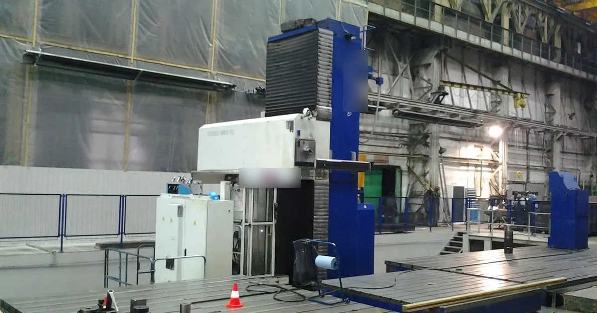 Floor-type horizontal boring machine beside a large machining table, the kind of machine used for line boring large frames