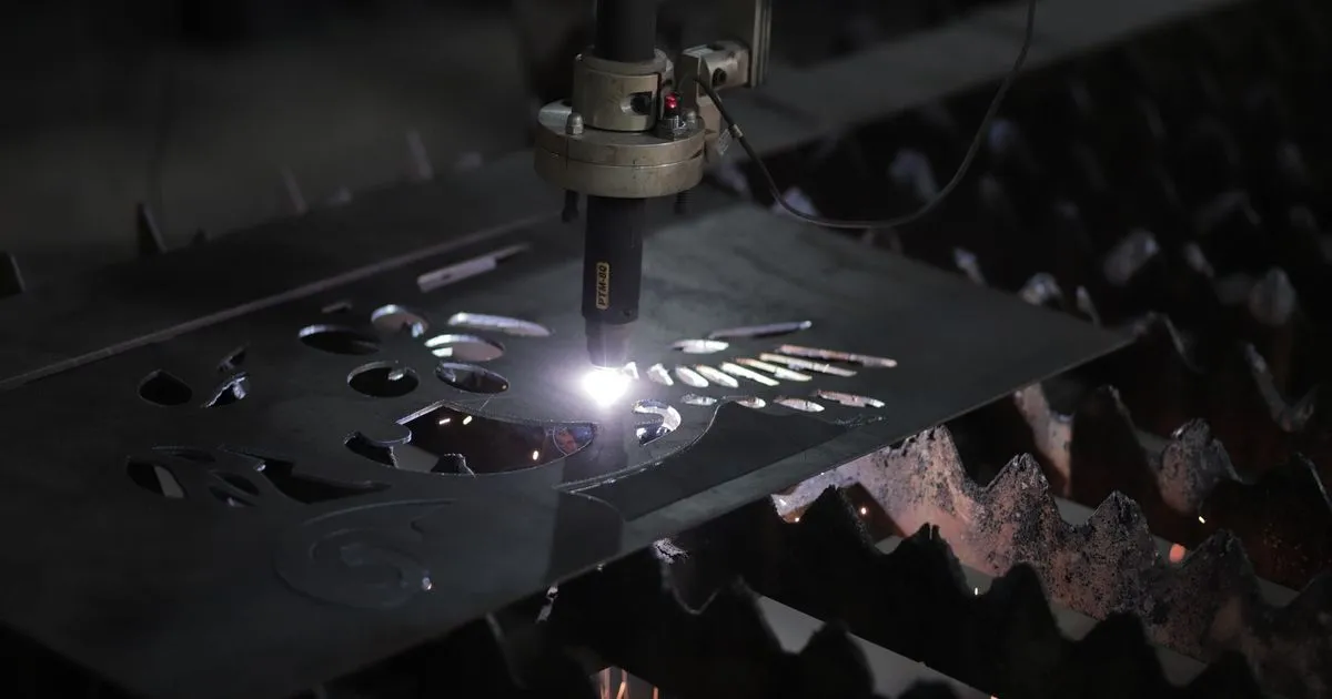 CNC plasma torch cutting steel plate on a slatted cutting table, an example of plasma vs oxy fuel cutting thick plate