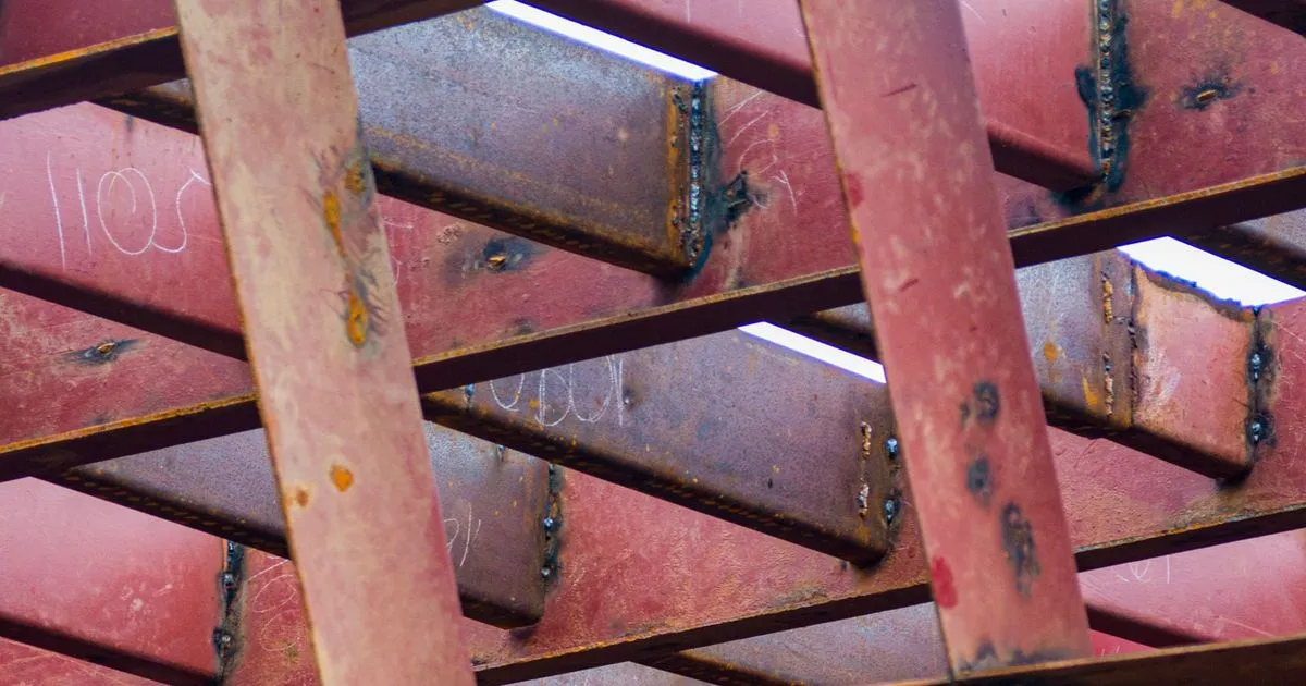 Welded joints on a red steel frame, the kind of weld a WPS PQR review covers before a heavy fabrication order